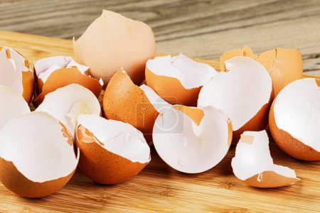 Photo for Close up of broken Organic Brown Eggshells on wooden background with copy space - Royalty Free Image
