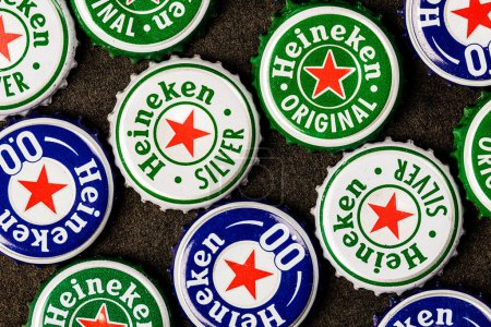 Téléchargez les photos : Gros plan des capsules de bière Heineke isolées sur un fond noir - en image libre de droit