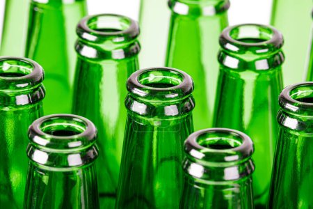 Téléchargez les photos : Gros plan de bouteilles de bière verte vides isolées sur un fond blanc avec espace de copie - en image libre de droit