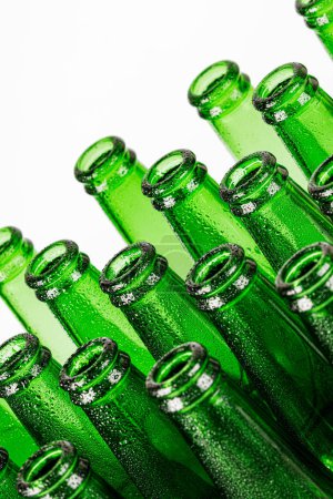 Téléchargez les photos : Gros plan de bouteilles de bière verte vides isolées sur un fond blanc avec espace de copie - en image libre de droit