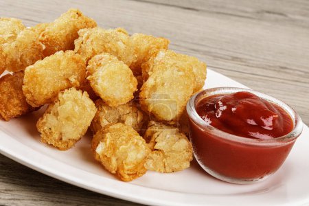 Photo for Close up of delicious Tater Tots on a wooden background with copy space - Royalty Free Image