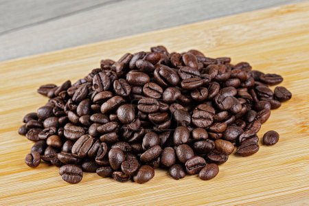 Foto de Primer plano de deliciosos granos de café asados sobre un fondo de madera con espacio para copiar - Imagen libre de derechos
