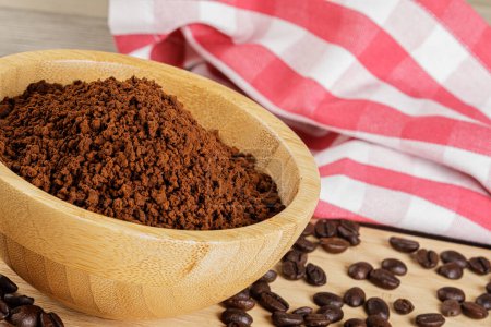 Photo for Wooden Bowl with fresh ground Roasted Coffee Grounds on wooden background with copy space - Royalty Free Image