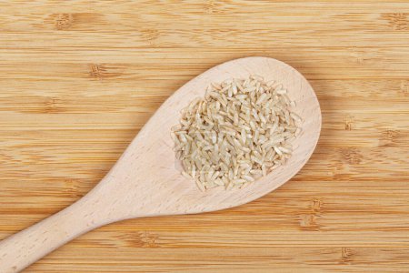 Photo for Flat Lay close up of delicious Brown Rice isolated with a wooden spoon and copy space - Royalty Free Image
