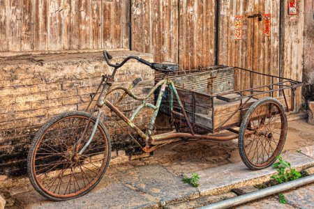 Téléchargez les photos : Un bicyle antique dans la vieille ville de Daxu, Guilin, Guangxi, Chine. La ville antique de Daxu a été formée au début de la dynastie Song. Ces structures forment principalement les dynasties Ming et Qing. - en image libre de droit