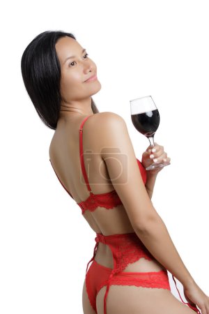 Photo for Young Asian Woman wearing red lingerie and holding a glass of red wine isolated on a white background with copy space - Royalty Free Image