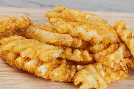 Photo for Delicious Waffle Fries isolated on a wooden background with copy space - Royalty Free Image