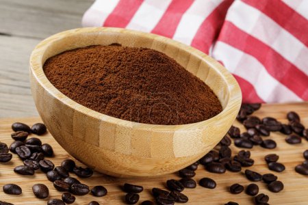 Photo for Close up of a wooden bowl of Fresh Ground Coffee isolated on a wooden background with copy space - Royalty Free Image