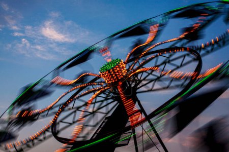 Téléchargez les photos : Amusement Rides with Movement Blur dans la soirée à la foire locale du comté avec espace de copie Kentucky, États-Unis, Amérique du Nord - en image libre de droit