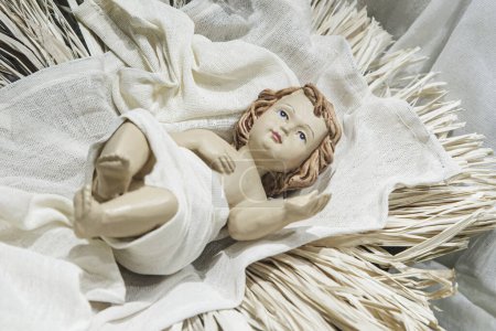 Téléchargez les photos : Une Figurine de l'Enfant Jésus couchée dans la Mangeoire isolée avec espace de copie - en image libre de droit