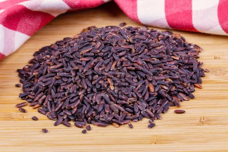 Photo for Close up of a pile of Healthy Black Rice isolated on a wooden background with copy space - Royalty Free Image
