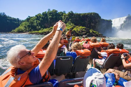 Foto de Turista en el río Paseo en barco acercándose a las cataratas. Cataratas del Iguazú es la serie más grande de cascadas en el planeta, ubicada en Brasil, Argentina, y Paraguay, América del Sur. - Imagen libre de derechos
