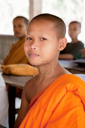 Téléchargez les photos : Un très jeune enfant claquant pour être moines bouddhistes au Cambodge, en Asie du Sud-Est - en image libre de droit