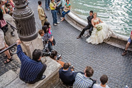 Photo for Bride and Groom being photographed at the Trevi Fountain in Rome Italy - Royalty Free Image