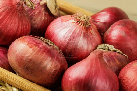 Photo for Close up of a basket of Red Onions on a wooden background with copy space - Royalty Free Image