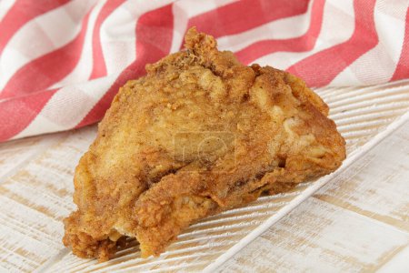 Foto de Primer plano del muslo de pollo frito sobre un fondo de madera con espacio de copia - Imagen libre de derechos