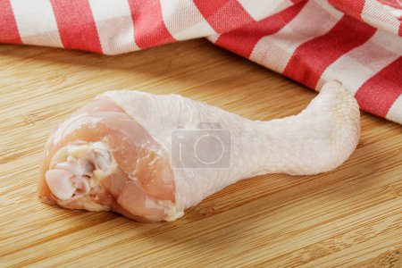 Photo for Close up of a raw Chicken Leg isolated on a wooden cutting board with copy space - Royalty Free Image