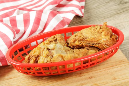 Photo for Red basket of delicious Drumsticks and Thighs of Fried Chicken  with copy space - Royalty Free Image