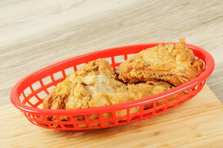 Foto de Canasta roja de deliciosos muslos y muslos de pollo frito con espacio para copiar - Imagen libre de derechos