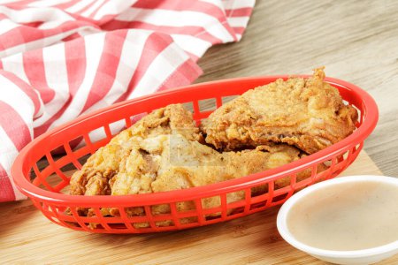Téléchargez les photos : Panier rouge de délicieux pilons et cuisses de poulet frit et sauce avec espace de copie - en image libre de droit