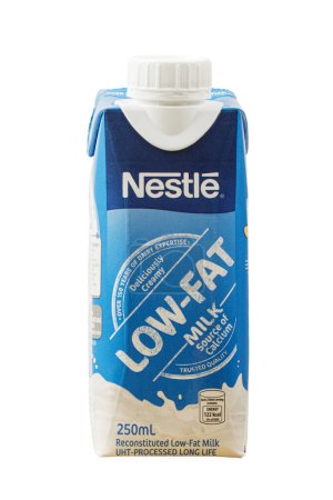 Téléchargez les photos : Gros plan d'une boîte de lait faible en gras Nestlé isolé sur un fond blanc avec espace de copie - en image libre de droit