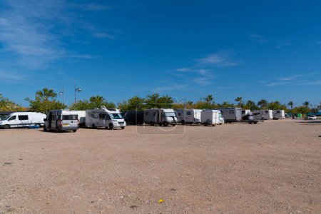 Téléchargez les photos : Camping-cars et camping-cars parking à la aire libre à Vinaros, Costa del Azahar Espagne sous le beau soleil et le ciel bleu - en image libre de droit