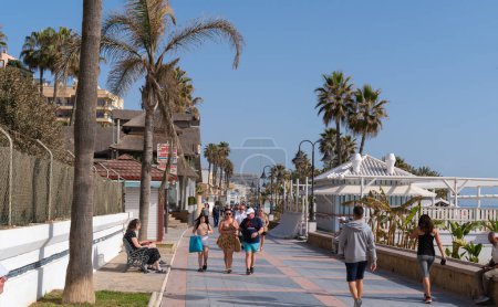 Photo for Tourists and visitors walking on the promenade paseo at La Carihuela, Torremolinos, Spain, Costa Del Sol on Thursday 23rd February 2023 - Royalty Free Image