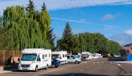 Photo for Motorhomes and campervans parked on the road next to the free aire at Area de Autocaravanas, Aguilar de Campoo, Palencia Province in Castile and Len, Spain on Tuesday 29th August 2023 - Royalty Free Image