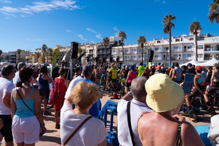Photo for Bicycle exercise class event with many people and a large crowd seafront promenade Peniscola, Spain Saturday 23rd September 2023 - Royalty Free Image