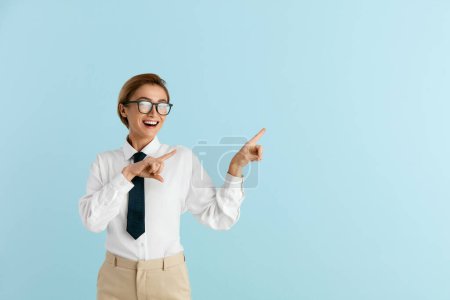 Photo for Smiling Businesswoman Pointing Hand. Positive Lady Pointing Away Paying Your Attention at Empty Space for Advertisement. Indoor Studio Shot Isolated on Blue Background - Royalty Free Image