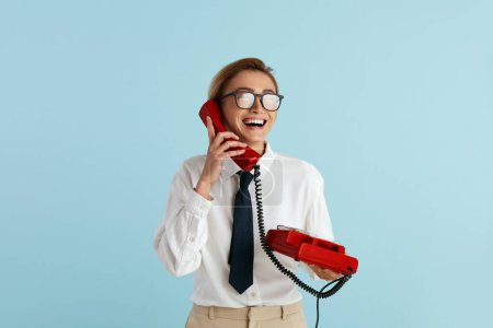 Photo for Businesswoman Talking Landline Telephone. Caucasian Woman Speaking on Smartphone, Smiling, Using Landline Phone for Communication. Modern Person Having Fun and Speaking on Call - Royalty Free Image