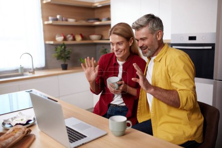 Photo for Smiling Couple Videocalling Laptop. Friendly Senior Spouses Talking With Family By Video Call Using Laptop. Technologies And People Concept - Royalty Free Image