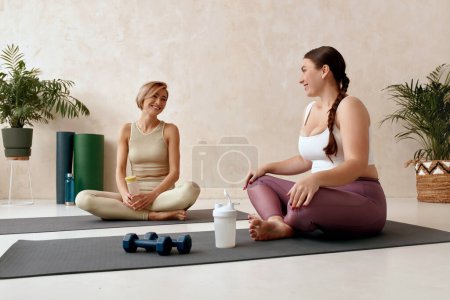 Photo for Smiling Woman Exercising Yoga. Female Friends Talking During Yoga Pilates Session Together At Home. Attractive Girls In Sportswear Using Mat Spending Free Leisure Time Exercise For Health Care - Royalty Free Image
