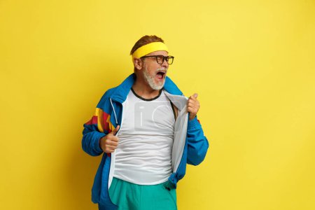 Foto de Hombre gritando celebrando. Guapo abuelo de pie sobre fondo amarillo aislado. Éxito. Concepto - Imagen libre de derechos