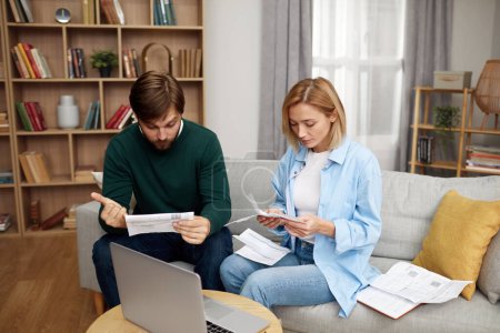 Photo for Serious Couple Paying Bills. Worried Couple Calculating And Paying Bills Online While Sitting At Home. Two people counting family budget - Royalty Free Image
