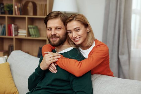 Photo for Romantic Couple Embracing Sofa. Happy Couple Relaxing On Couch At Home. Smiling Loving Spouses Resting In Cozy Living Room Interior, Embracing On Sofa, Enjoying Weekend Time Together - Royalty Free Image