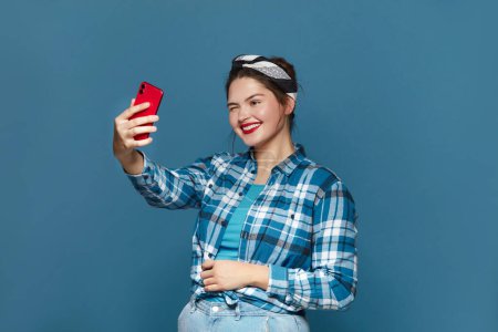 Téléchargez les photos : Happy Woman Making Selfie Smartphone. Plus Size Girl Smiling And Winking While Videocalling Cellphone, Shooting Content For Social Media, Enjoying Mobile - en image libre de droit