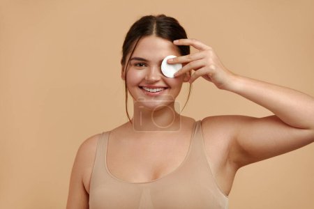 Photo for Woman Cleaning Face With White Pad. Beautiful Girl Removing Makeup White Cosmetic Cotton Pad. Happy Female Taking Off Makeup From Facial Skin With Cosmetic Pad. Hight Quality Image - Royalty Free Image