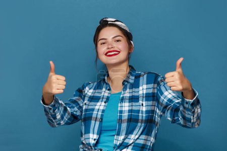 Foto de Smiling Woman Showing Big Fingers Isolated. Happy Plus Size Girl Looking at Camera with Toothy Smile and Showing Thumb Up, Approval Sign, Satisfied with Service, Good Feedback. Indoor Shot - Imagen libre de derechos