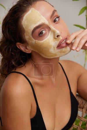 Foto de Face Mask Woman. Young Relaxed Woman Enjoying Skin Care Routine at Street. Attractive Woman With Makeup And Clay Mask On Her Skin. Spa Procedure Concept - Imagen libre de derechos