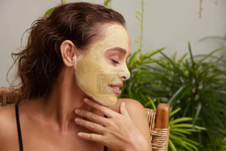 Foto de Face Mask Woman. Young Relaxed Woman Enjoying Skin Care Routine at Street. Attractive Woman With Makeup And Clay Mask On Her Skin. Spa Procedure Concept - Imagen libre de derechos