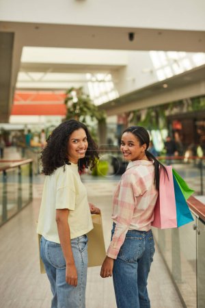 Téléchargez les photos : Deux femmes souriant tout en faisant du shopping ensemble dans un magasin. - en image libre de droit