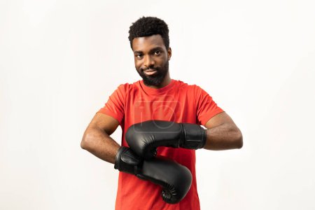 Photo for Portrait of a confident African American man wearing boxing gloves, ready for training. Isolated on white, this image conveys determination, strength, and a healthy lifestyle. - Royalty Free Image