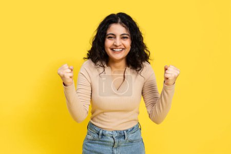 Photo for Excited Young Woman Celebrating Success On Yellow Background. Energetic, Joyful, Winner Concept. Good For Advertising And Lifestyle Blogs. - Royalty Free Image