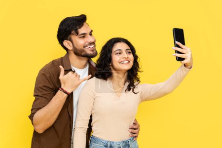 Foto de Pareja tomando selfie con Smartphone Shaka signo fondo amarillo - Imagen libre de derechos