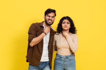 Uncomfortable Young Couple Feeling Choked, Overwhelmed Emotion, Stress Concept on Yellow Background
