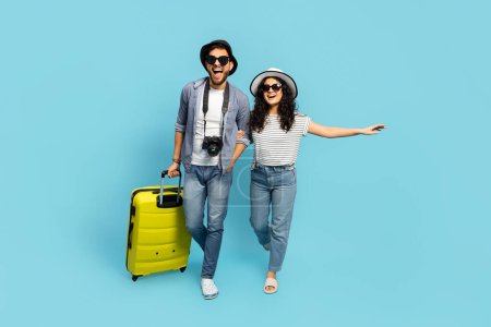 Feliz pareja viajando vacaciones de verano moda estilo cámara amarillo maleta emoción alegría fondo azul
