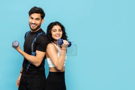 Photo for A Happy, Energetic Couple Engages In A Fun Workout Session, Holding Dumbbells And Smiling Against A Vibrant Blue Background. This Image Captures The Concept Of Fitness, Exercise, And Shared Wellness. - Royalty Free Image