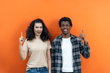 Photo for Happy Couple Pointing Up Ideas On Orange Background, Smiling Man Woman, Casual Clothes, Diverse Ethnicity, Eureka Moment, Creative Concept, Copy Space - Royalty Free Image