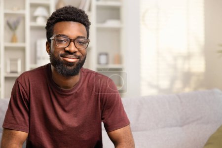 Photo for Smiling Young Man In Casual Home Setting Exuding Happiness And Confidence. Portrait Depicts Cheerfulness And Relaxed Lifestyle. Ideal For Ads, Magazines, And Positive Messaging. - Royalty Free Image